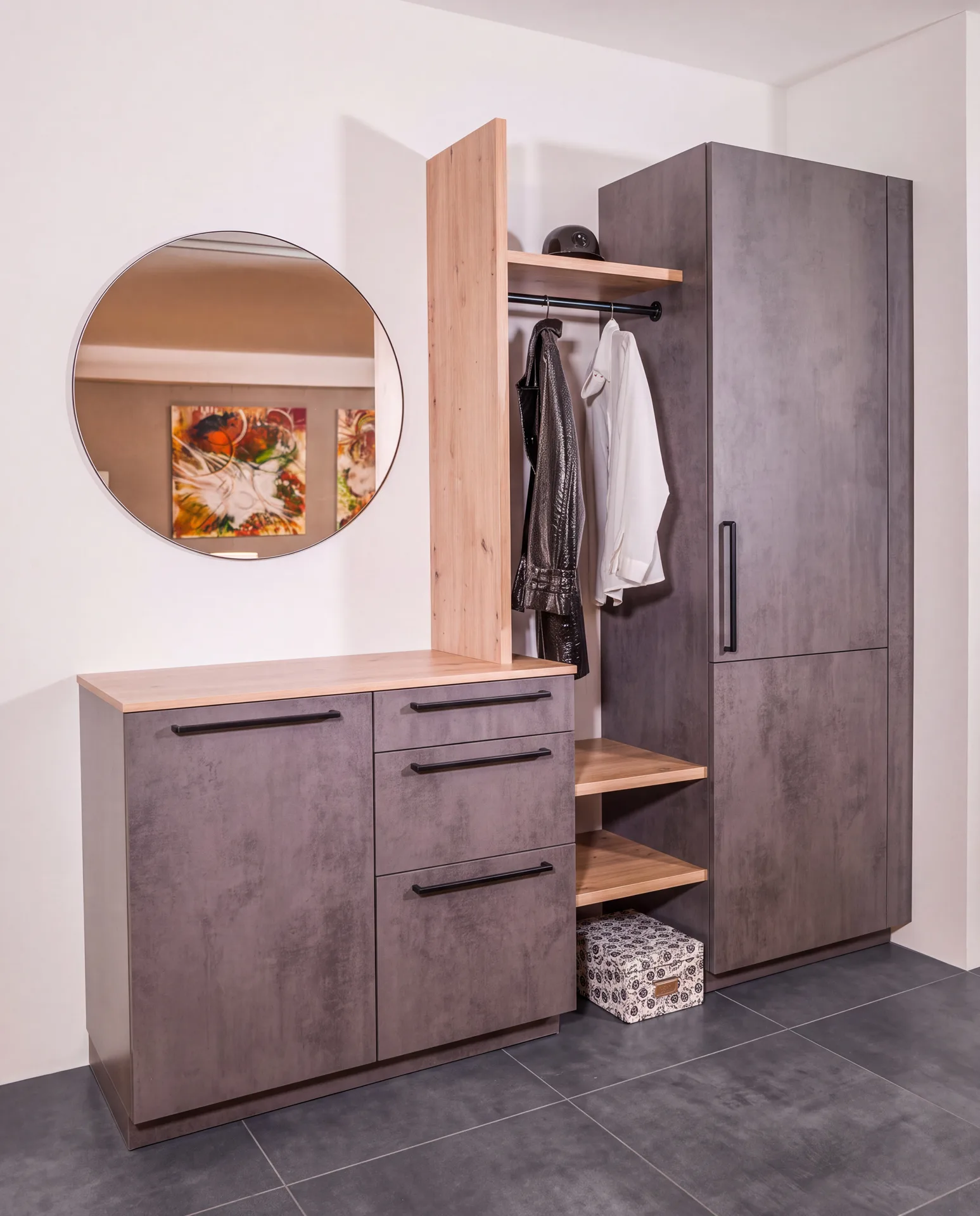 Garderobe in Betonoptik mit Holzregal und rundem Spiegel